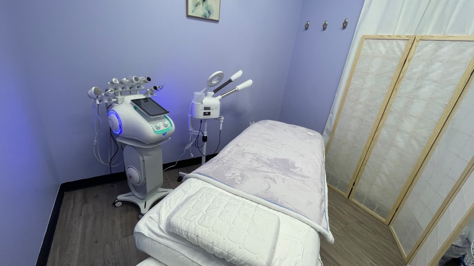 Professional facial equipment beside the treatment bed